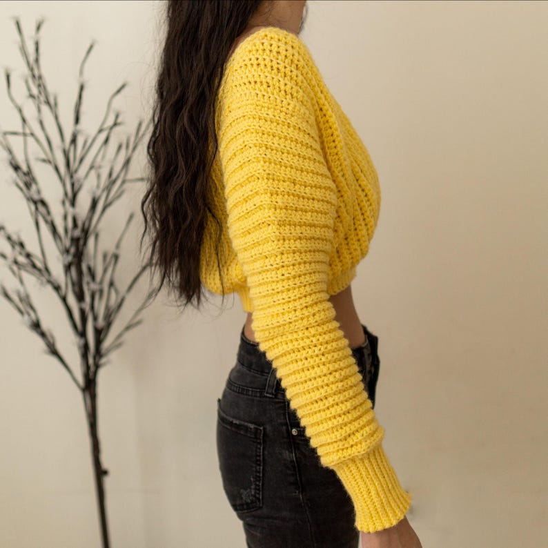 TCDDIY crochet pattern for a cropped off-the-shoulder V-neck sweater with versatile styling options, made with Lion Brand Pound of Love yarn in Honey Bee, side view.