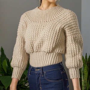 TCDDIY crochet pattern for a modern wide-collar Trinity stitch 3/4 sleeve sweater with a customizable fit, crafted using Baby Bernat Sport yarn in Baby Taupe.