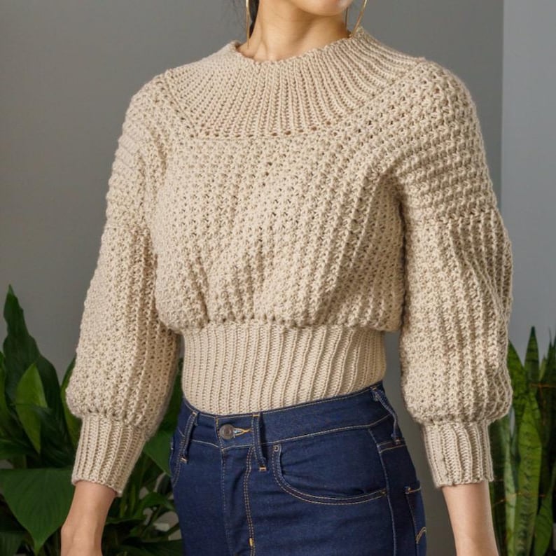 TCDDIY crochet pattern for a modern wide-collar Trinity stitch 3/4 sleeve sweater with a customizable fit, crafted using Baby Bernat Sport yarn in Baby Taupe.