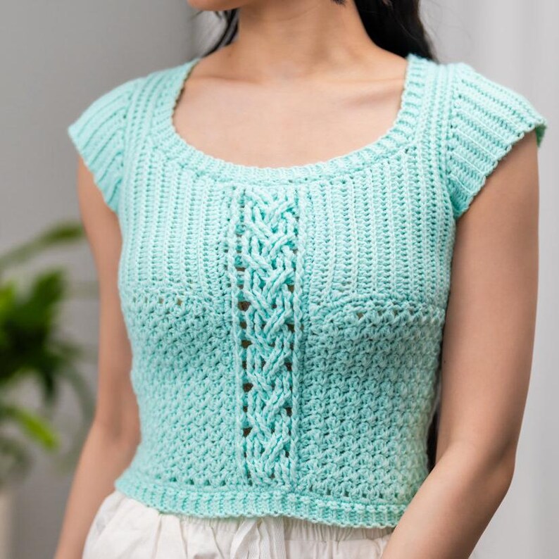 TCDDIY crochet pattern for a short sleeve cable stitch top with ribbing, featuring a cozy Suzette stitch texture, made using Lion Brand Pound of Love yarn in Pastel Green.
