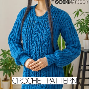 Puede incluir: Un suéter de crochet azul con un patrón de punto de cable y un ajuste holgado. El suéter tiene un cuello redondo y mangas largas. CROCHET PATTERN está escrito en texto blanco en la parte inferior de la imagen.