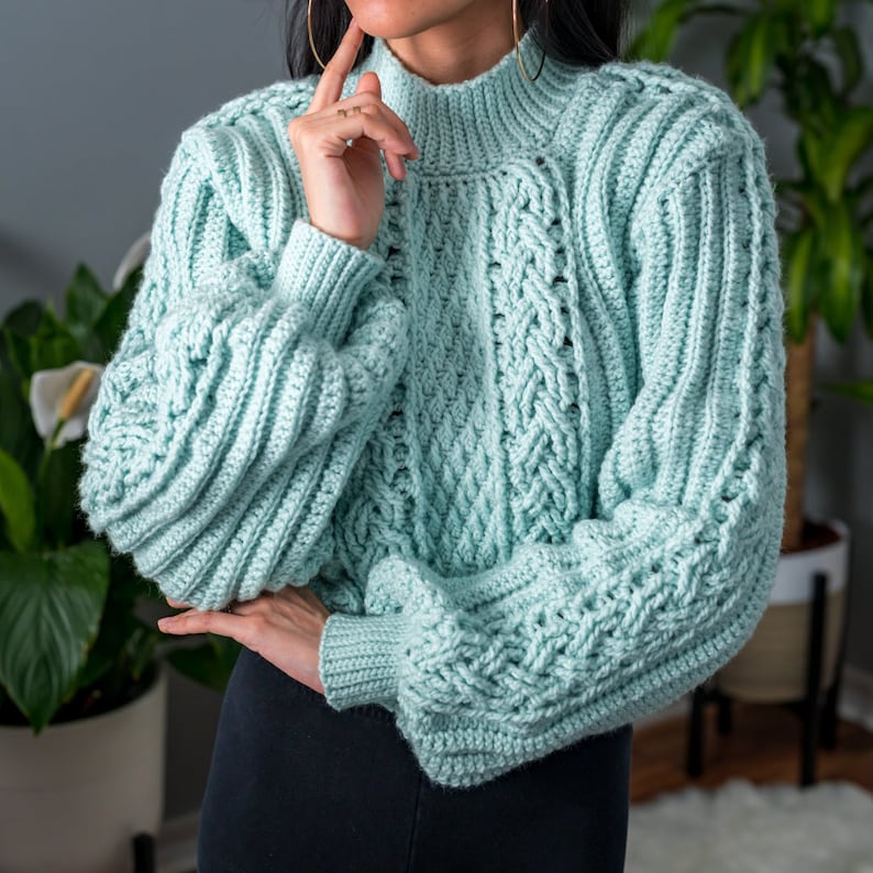 TCDDIY crochet pattern for a cropped cable stitch sweater with a mock neck and alpine stitch detailing, crafted using Caron One Pound yarn in Pale Green.