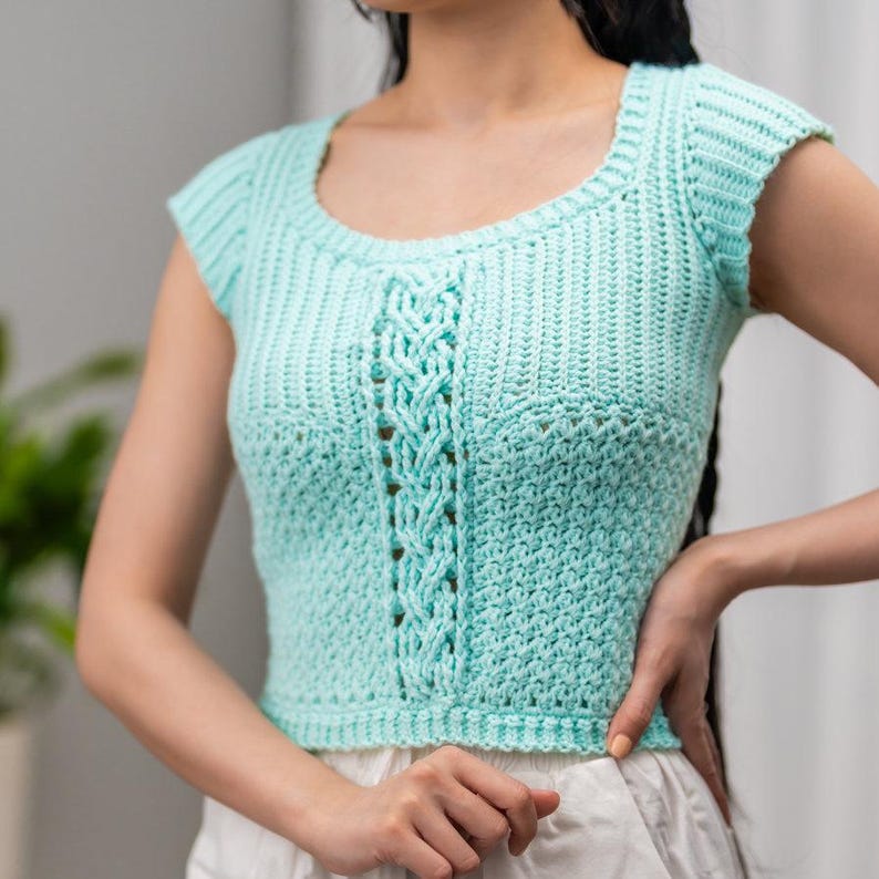 TCDDIY crochet pattern for a short sleeve cable stitch top with ribbing, featuring a cozy Suzette stitch texture, made using Lion Brand Pound of Love yarn in Pastel Green.