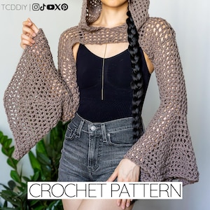 Puede incluir: Un chaleco de ganchillo marrón con capucha y mangas acampanadas. El diseño abierto es visible, y el texto "CROCHET PATTERN" se muestra en la parte inferior. El chaleco se lleva sobre un top negro y unos shorts vaqueros.