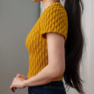 TCDDIY crochet pattern for a modern short sleeve crew neck t-shirt with almond stitch detail, crafted using Lion Brand Pound of Love yarn in Maize, side view.