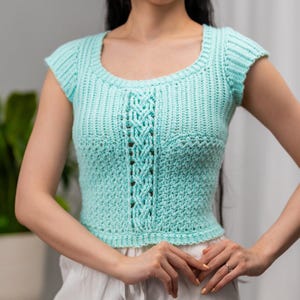 TCDDIY crochet pattern for a short sleeve cable stitch top with ribbing, featuring a cozy Suzette stitch texture, made using Lion Brand Pound of Love yarn in Pastel Green.