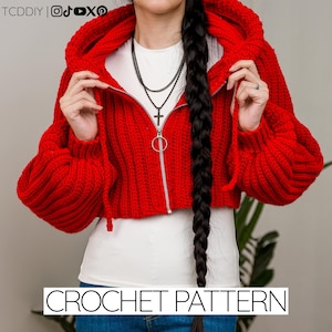 May include: A cropped red crochet hoodie with a zipper closure and a hood. The hoodie has long sleeves and is worn over a white top. The text "CROCHET PATTERN" is displayed at the bottom of the image.