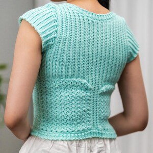 TCDDIY crochet pattern for a short sleeve cable stitch top with ribbing, featuring a cozy Suzette stitch texture, made using Lion Brand Pound of Love yarn in Pastel Green.