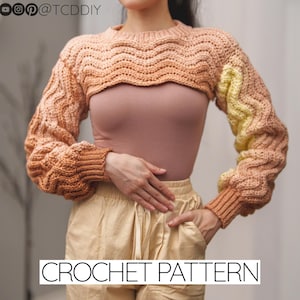 Puede incluir: Un patrón de crochet para un suéter corto con mangas largas. El suéter está hecho en un degradado de hilo de melocotón, naranja y amarillo. El patrón está disponible para su compra.