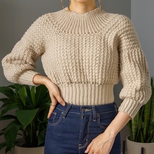 TCDDIY crochet pattern for a modern wide-collar Trinity stitch 3/4 sleeve sweater with a customizable fit, crafted using Baby Bernat Sport yarn in Baby Taupe.