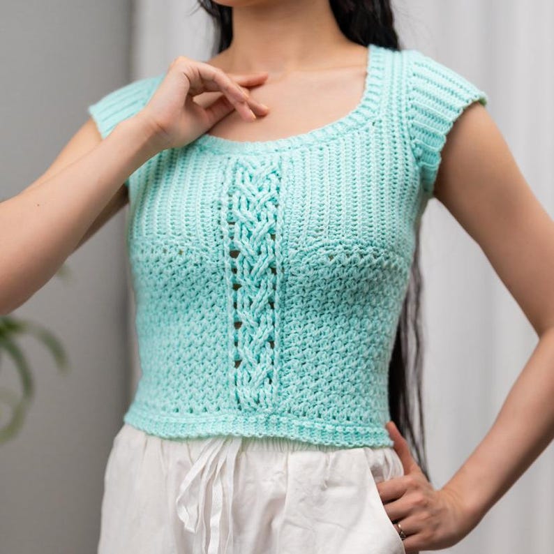 TCDDIY crochet pattern for a short sleeve cable stitch top with ribbing, featuring a cozy Suzette stitch texture, made using Lion Brand Pound of Love yarn in Pastel Green.