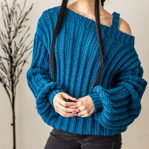 TCDDIY crochet pattern for a single strap sweater dress featuring balloon sleeves and a customizable length, crafted using Caron One Pound yarn in Ocean.