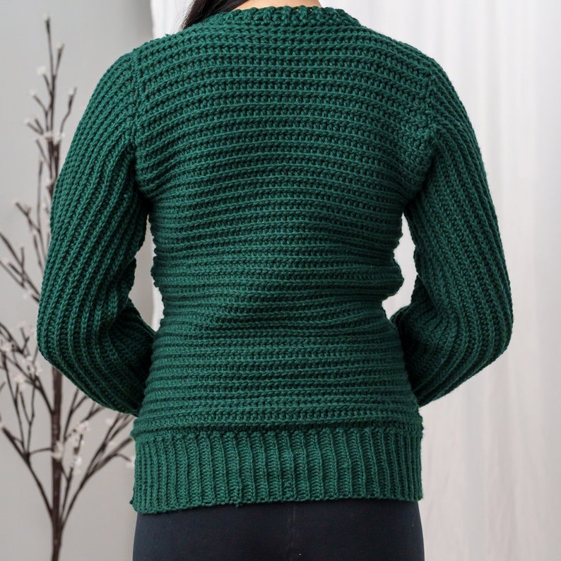 TCDDIY crochet pattern for a classic cropped crewneck sweater featuring cable and alpine stitches with ribbing details, made using Big Twist Soft yarn in Hunter Green, back view.