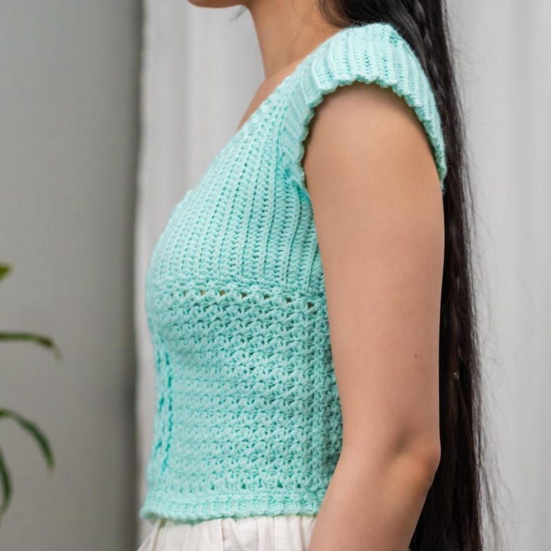 TCDDIY crochet pattern for a short sleeve cable stitch top with ribbing, featuring a Suzette stitch texture, made using Lion Brand Pound of Love yarn in Pastel Green, side view.