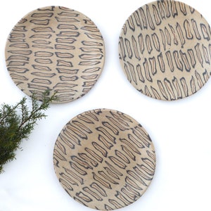 May include: A set of three ceramic mugs with a speckled, matte finish. The mugs are in shades of cream, light gray, and dark gray. Each mug has a simple, minimalist design, perfect for coffee or tea.