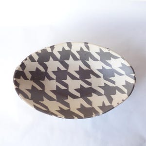 May include: A white ceramic mug with a black handle and the text "But First, Coffee" in a black, handwritten-style font. The mug is on a white surface.