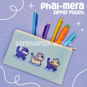 May include: A light blue zipper pouch with the text "Phai-mera ZIPPER POUCH" and the words "serendipity.draws". The pouch features three cartoon animal illustrations. Several pens and a carrot-shaped highlighter are inside.