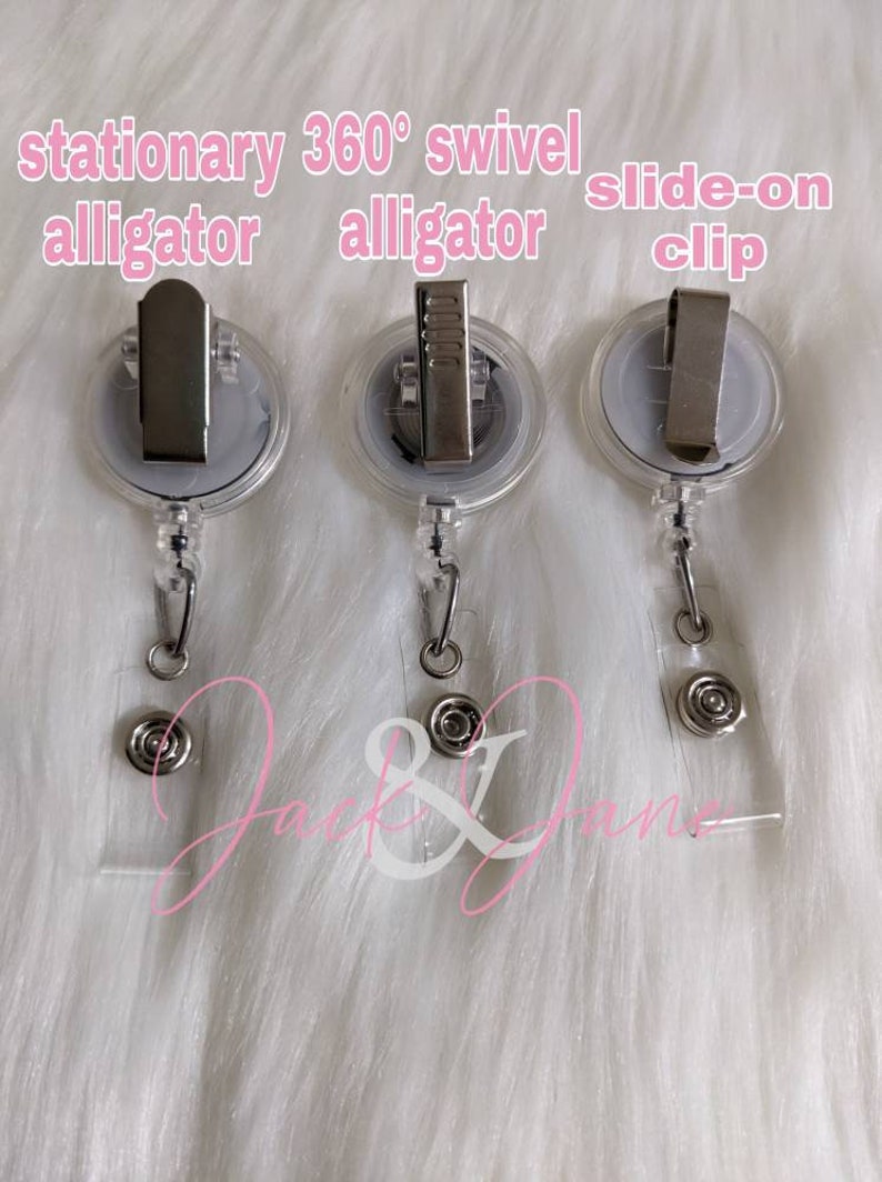 May include: Three clear plastic retractable badge holders with different types of clips. The first holder has a stationary alligator clip, the second has a 360 degree swivel alligator clip, and the third has a slide-on clip.