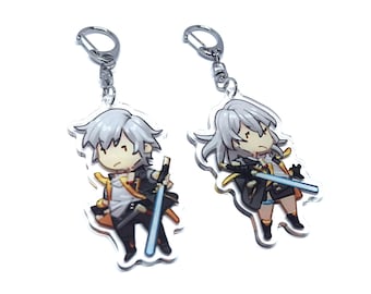 May include: Two silver keychains with clear acrylic charms featuring anime-style characters. The characters have white hair, are wearing black and yellow outfits, and are holding swords.