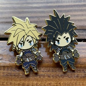 May include: Two enamel pins depicting chibi characters with spiky hair. One pin has golden hair, the other black. Both have blue eyes, black and blue outfits, and gold accents. The pins are on a wooden surface.