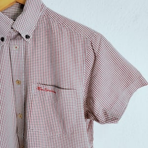 K&ouml;nnte beinhalten: Ein kurz&auml;rmeliges Hemd mit Knopfleiste und einem rot-wei&szlig;en Vichy-Karo-Muster. Das Hemd verf&uuml;gt &uuml;ber einen Button-Down-Kragen, eine Brusttasche mit dem roten Sticktext Ben Sherman und helle Kn&ouml;pfe entlang der vorderen Knopfleiste.