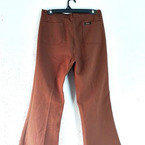 Puede incluir: Una taza de cerámica blanca con asa negra y el texto "But First, Coffee" en negrita negra. La taza se encuentra sobre un fondo borroso, sugiriendo un ambiente acogedor.