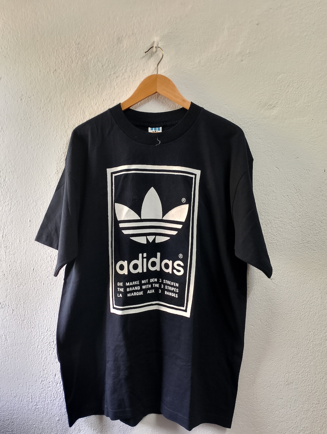 the brand with the 3 stripes shirt