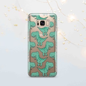 Peut inclure: Une coque de t&eacute;l&eacute;phone transparente avec un motif de dinosaures de dessin anim&eacute; verts sur un fond dor&eacute;. La coque est con&ccedil;ue pour un t&eacute;l&eacute;phone Samsung Galaxy.