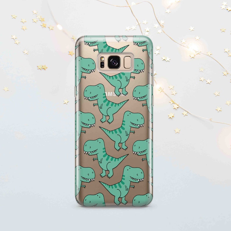 Peut inclure: Une coque de t&eacute;l&eacute;phone transparente avec un motif de dinosaures de dessin anim&eacute; verts sur un fond dor&eacute;. La coque est con&ccedil;ue pour un t&eacute;l&eacute;phone Samsung Galaxy.
