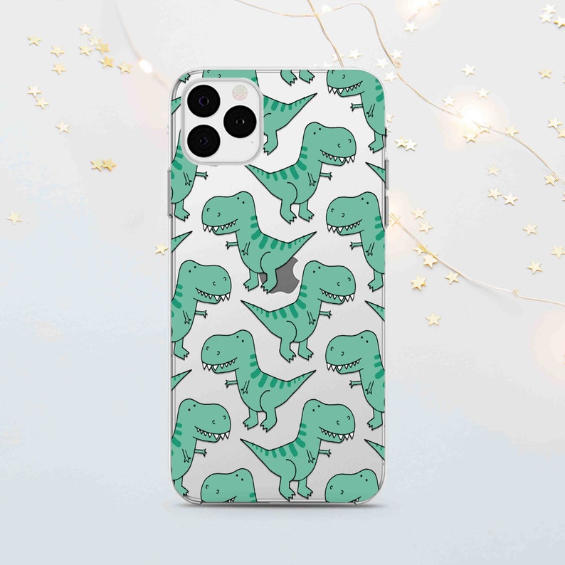 Peut inclure: Une coque de t&eacute;l&eacute;phone transparente avec un motif r&eacute;p&eacute;t&eacute; de dinosaures de dessin anim&eacute; verts. La coque est con&ccedil;ue pour un iPhone.