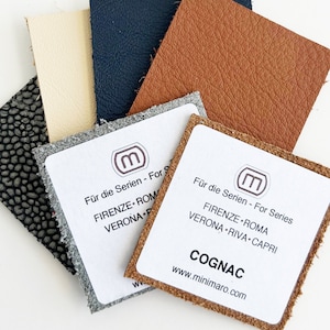 May include: Leather swatches in various colors, including beige, navy blue, gray, and brown. Each swatch has a white label with the text "Für die Serien - For Series" and the company logo. The brown swatch has the text "COGNAC" and the website address "www.minimaro.com".