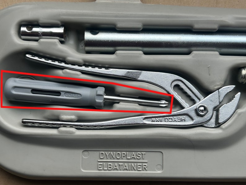 May include: A gray and silver multi-tool set in a gray plastic case. The set includes a pair of pliers, a screwdriver, and a wrench. The case has the text "Dynoplast Elbatainer" printed on it.