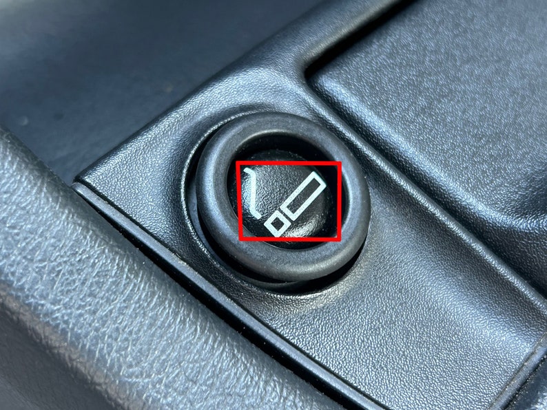 May include: A black plastic car cigarette lighter with a white cigarette symbol.