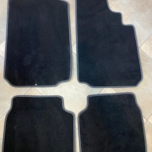 Peut inclure: Quatre tapis de sol de voiture noirs avec des bordures grises. Les tapis sont faits d'un matériau doux et moelleux et sont conçus pour protéger l'intérieur de la voiture de la saleté et de l'usure.