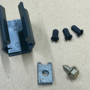 May include: A black plastic bracket with three black screws and a metal bracket with a single gold screw.