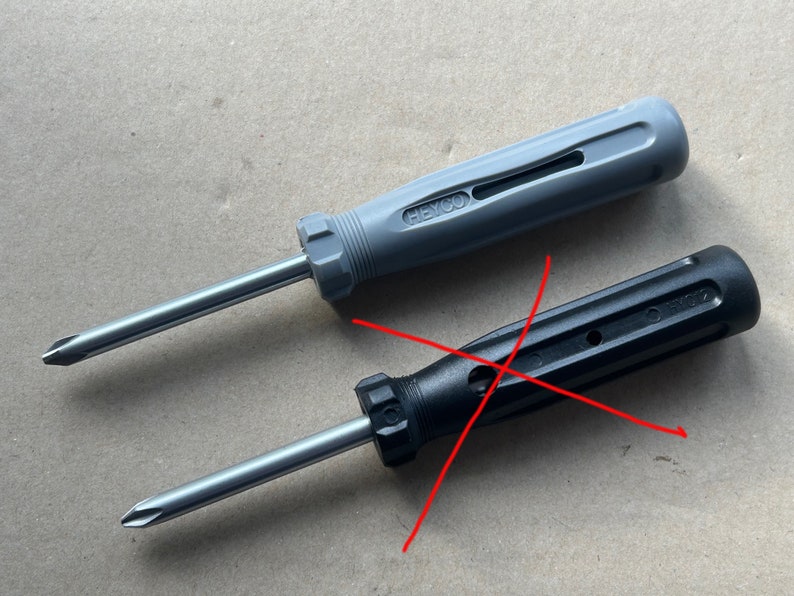May include: Two screwdrivers, one with a gray handle and the other with a black handle. The gray screwdriver has the text "HEYCO" on the handle. Both screwdrivers have a silver metal shaft.