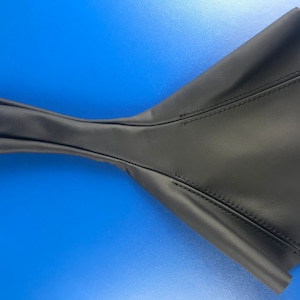May include: Black leather gear shift boot with a long, narrow shaft and a wide, flared base. The boot is stitched with black thread.