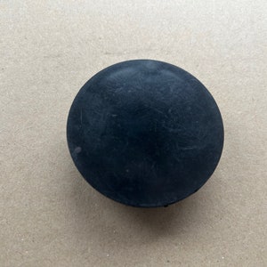 May include: A black plastic cap for a bottle or container.