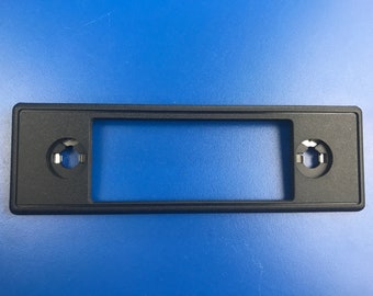 May include: Black plastic radio trim kit with two round holes for knobs.