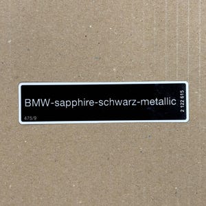Może przedstawiać: Czarno-biała etykieta z tekstem "BMW-sapphire-schwarz-metallic" i numerami "475/9" i "2 122 615".