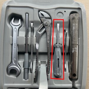 May include: A gray plastic tool case with a variety of tools, including a wrench, pliers, a screwdriver, and a metal rod. The case has the word "ELDATAINER" printed on it.