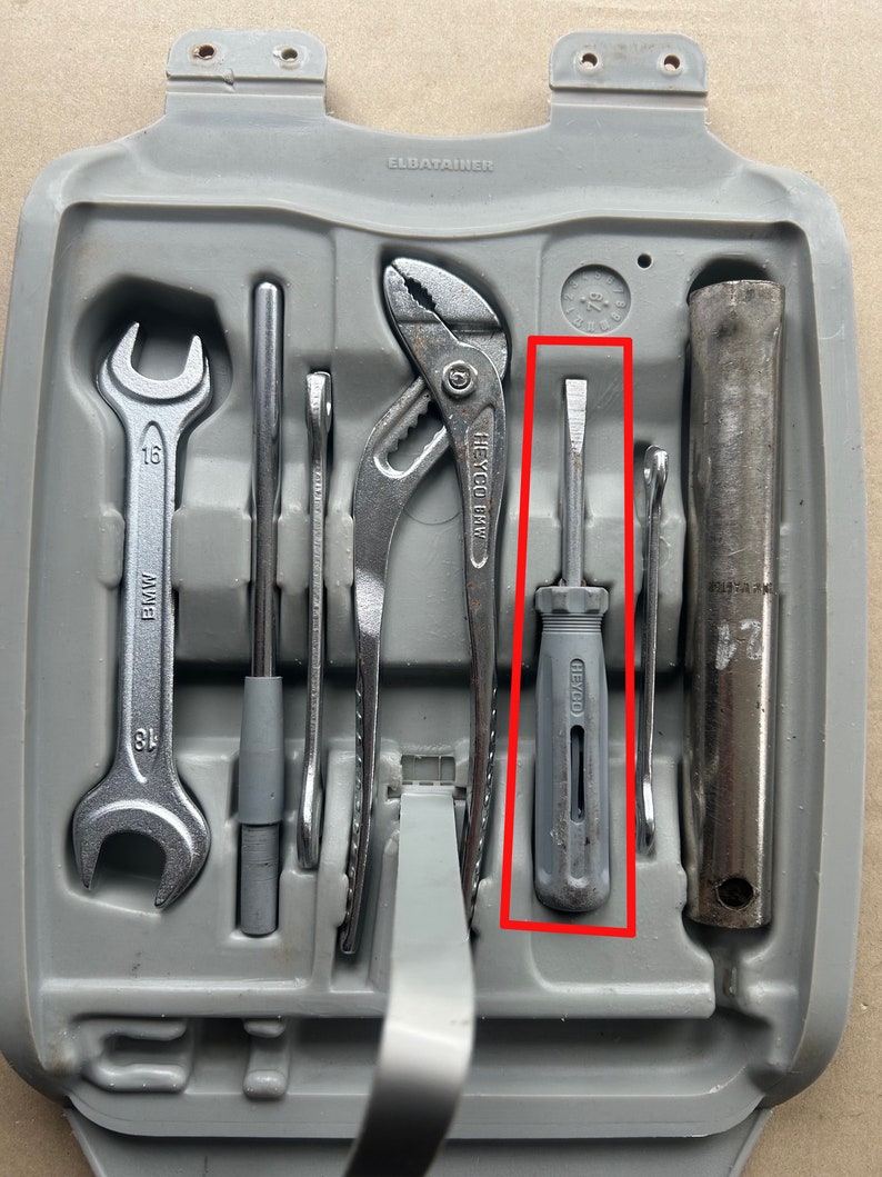 May include: A gray plastic tool case with a variety of tools, including a wrench, pliers, a screwdriver, and a metal rod. The case has the word "ELDATAINER" printed on it.