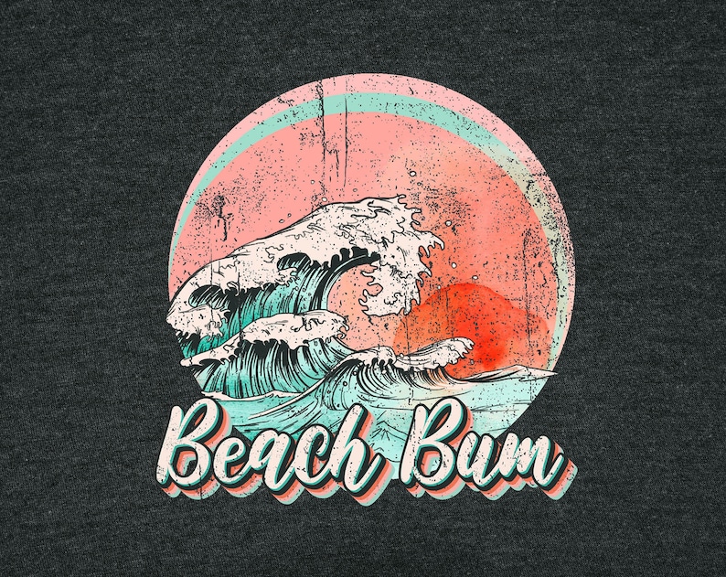 May include: Dark gray t-shirt with a distressed graphic of a wave, a setting sun, and a pink and blue circle. The text "Beach Bum" is in a retro font.
