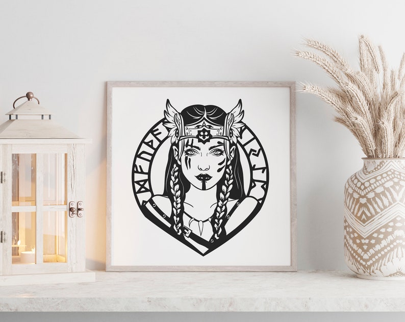 May include: Black and white illustration of a woman with a crown and wings, surrounded by a circle of runes. The text "Valkyrie" is written in runes around the circle.