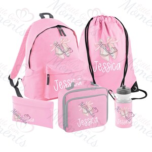 Puede incluir: Un conjunto escolar rosa que incluye mochila, bolsa de deporte, estuche, bolsa de almuerzo y botella de agua. Cada artículo presenta un diseño de zapatillas de ballet y el nombre "Jessica".