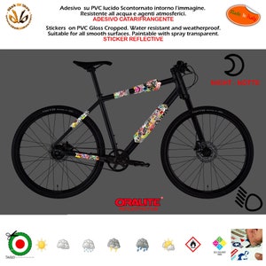 May include: A black bicycle with colourful stickers on the frame. The bicycle has a reflective sticker on the frame that reads "Oralite Reflective Film". The image also includes text that reads "Adesivo su PVC lucido Scontornato intorno l'immagine. Resistente all acqua e agenti atmosferici. Adesivo Catarifrangente Stickers on PVC Gloss Cropped. Water resistant and weatherproof. Suitable for all smooth surfaces. Paintable with spray transparent. Sticker Reflective Night Notte".