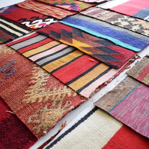 May include: A collection of colorful, rectangular woven textile samples. The samples feature various patterns, including stripes, geometric designs, and floral motifs. The color palette includes reds, blues, yellows, and earth tones, showcasing a variety of textures and styles.