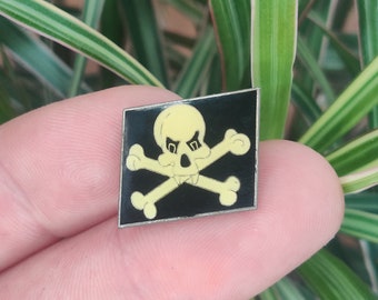 Skull and cross bones vintage enamel lapel pin.