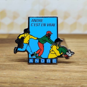Andre french fashion pin badge. Hat Tie Lapel bag denim or leather jacket. Vintage retro collectable advertising collectable gift.