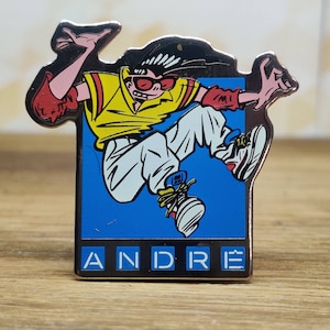 Andre french fashion pin badge. Hat Tie Lapel bag denim or leather jacket. Vintage retro collectable advertising collectable gift.